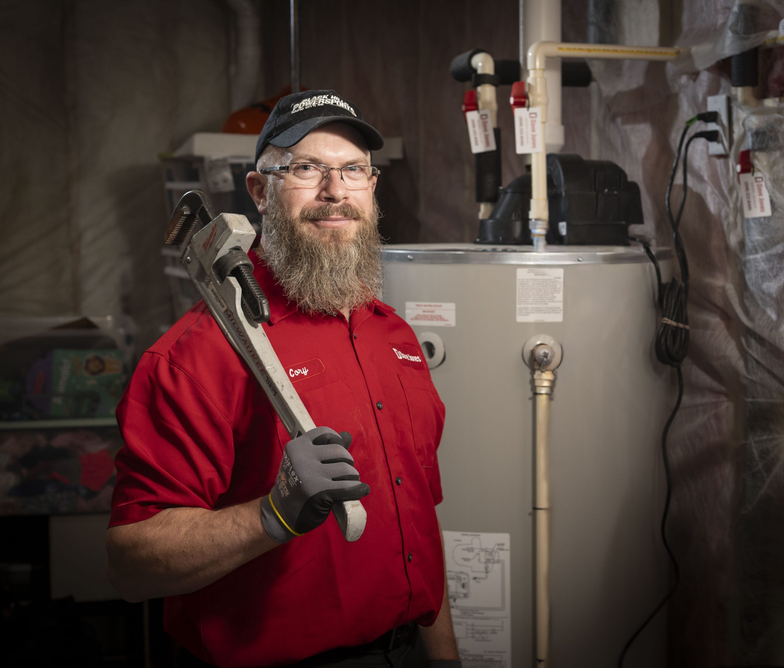 Dave Jones Plumber standing near water heater