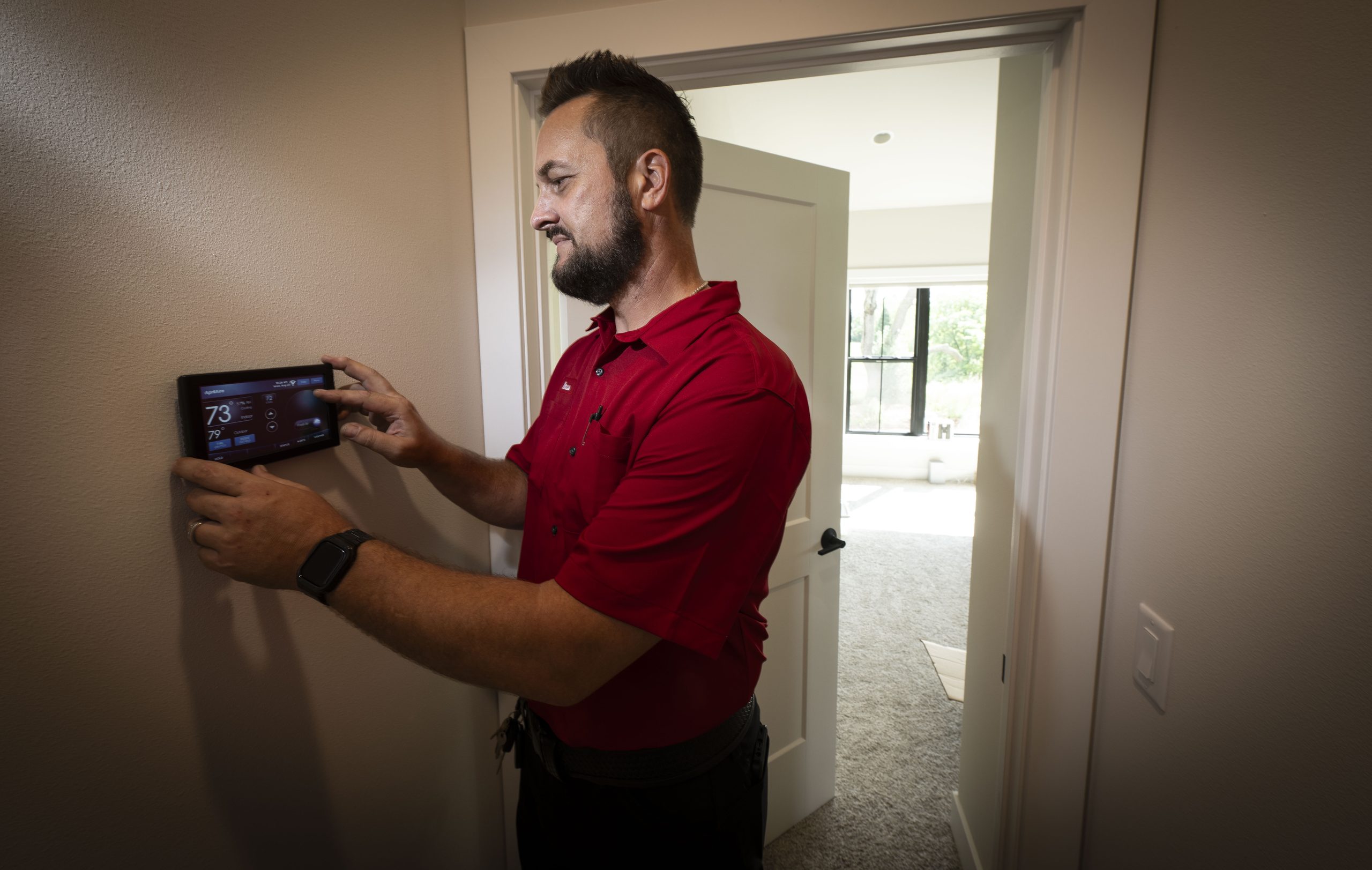 Dave Jones HVAC Technician at a thermostat
